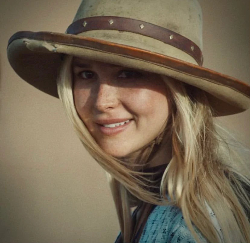 Actress portraying Elsa Dutton in the 1883 series wearing a handmade wide brim western hat with leather banding, studs, and a stampede strap.