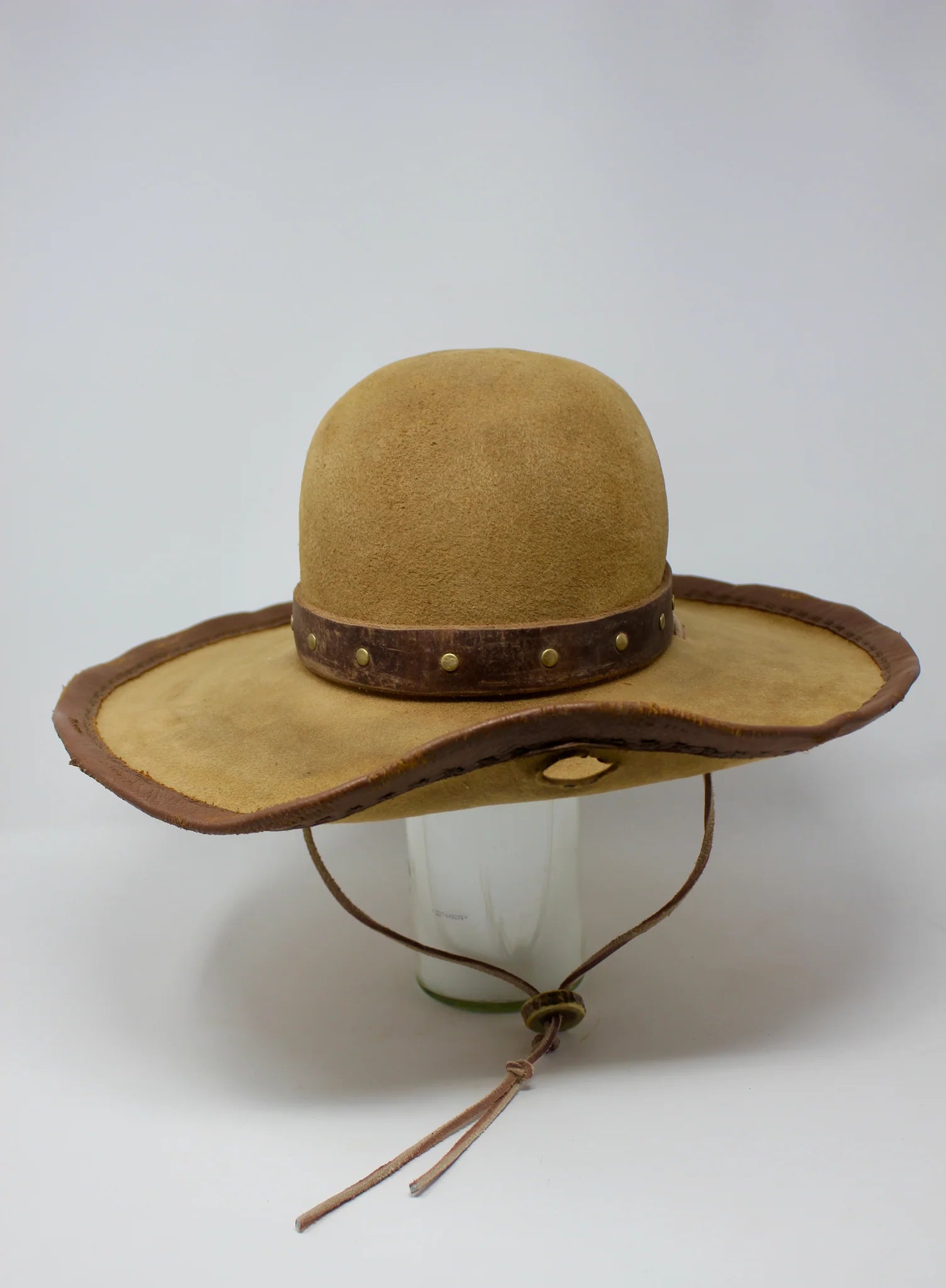 Handmade wide brim hat inspired by Elsa “Lightning with the Yellow Hair” from the 1883 series with leather band, studs, and stampede strap, front view.