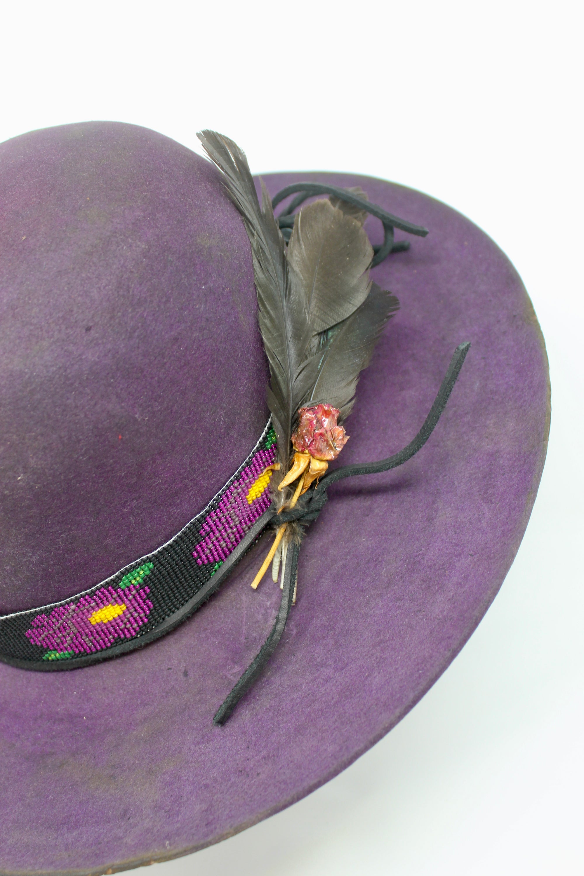 Close up view of  the hand-beaded floral band on the Plum Crazy hat by Lone Hawk Hats featuring hand-dyed purple vintage beaver felt, an open crown.