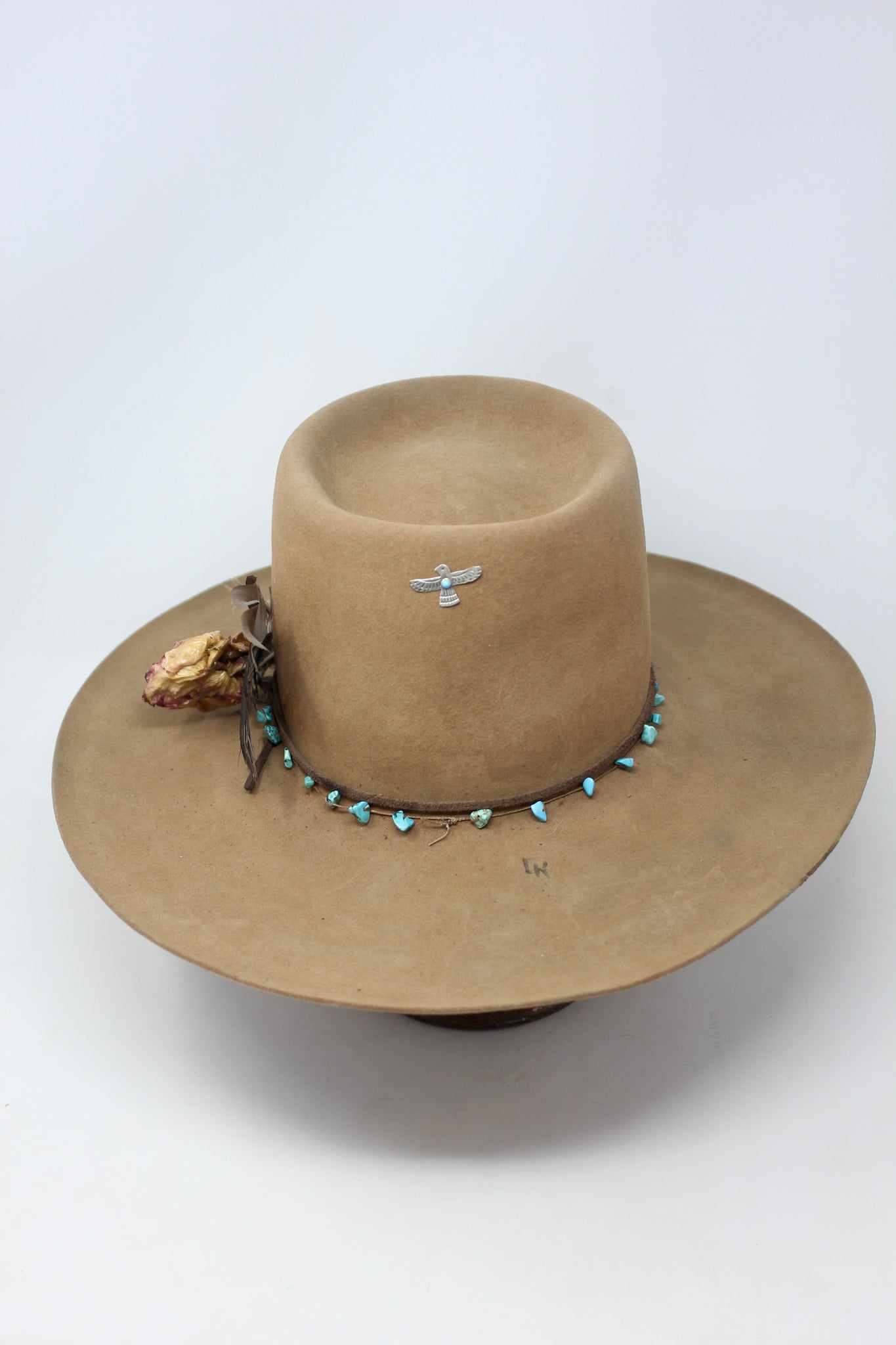 Full Front view of the Tele Top Camel hat by Lone Hawk Hats featuring a dipped telescope crown, wider brim, hand-knotted turquoise band, sterling hawk pin, and found feather accent.