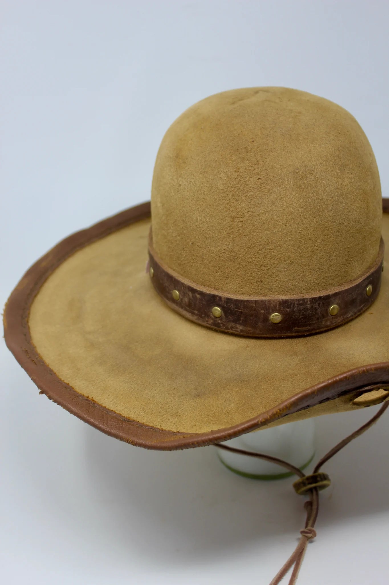 partial view of Handmade wide brim hat inspired by Elsa “Lightning with the Yellow Hair” from the 1883 series with leather band, studs, and stampede strap.