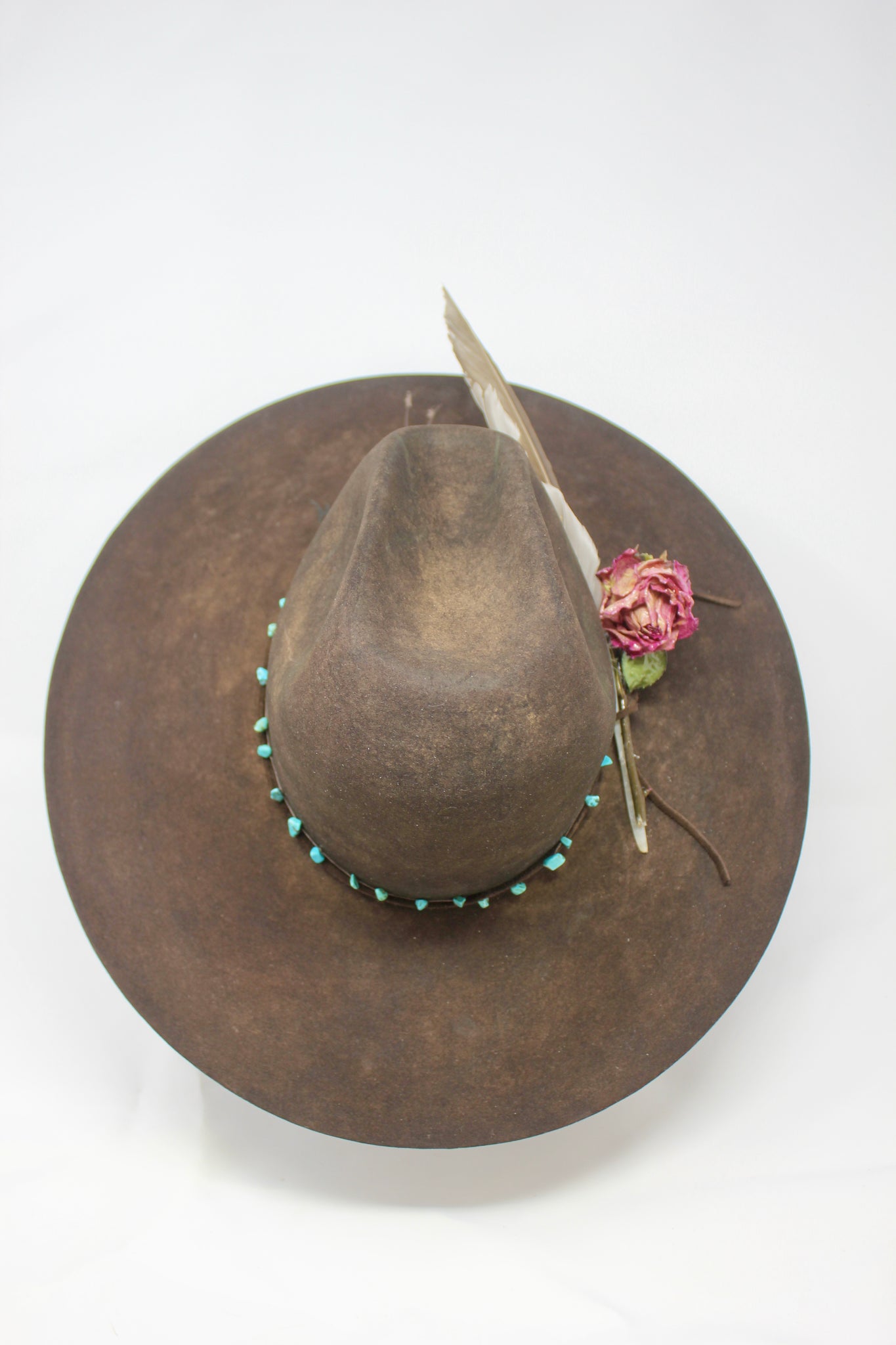 top view of the Lone Hawk wide brim tall crown western hat in vintage beaver felt featuring a hand-tied turquoise band, dried rose accent, and high-front low-back shaping.