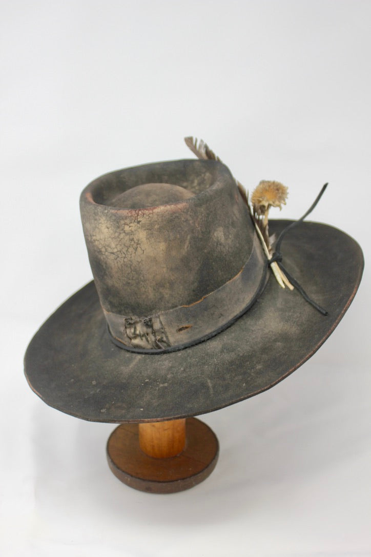 The Kid by Lone Hawk Hats, a handmade black beaver blend hat featuring hand distressing, a stitched band, and a found feather accent.