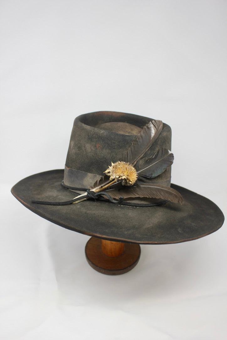The Kid by Lone Hawk Hats, a handmade black beaver blend hat featuring hand distressing, a stitched band, and a found feather accent.