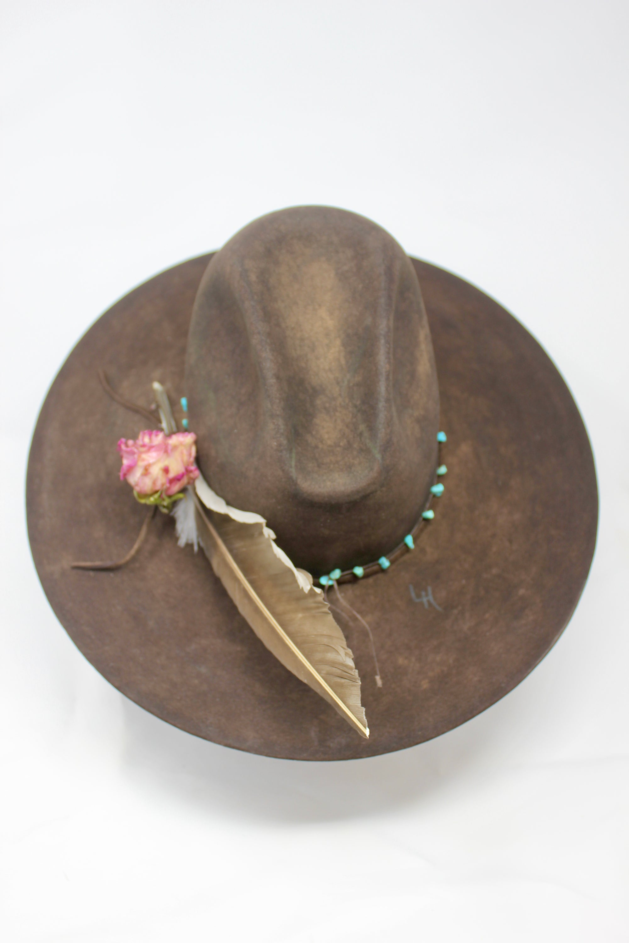 Back top view of the Lone Hawk wide brim tall crown western hat in vintage beaver felt featuring a hand-tied turquoise band, dried rose accent, and high-front low-back shaping.