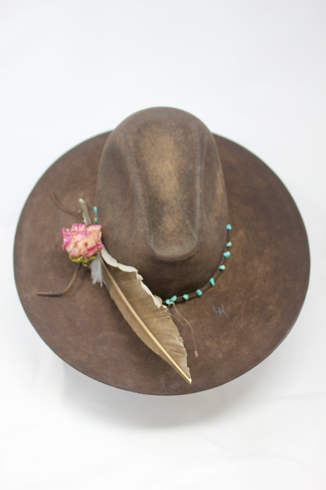 Back top view of the Lone Hawk wide brim tall crown western hat in vintage beaver felt featuring a hand-tied turquoise band, dried rose accent, and high-front low-back shaping.