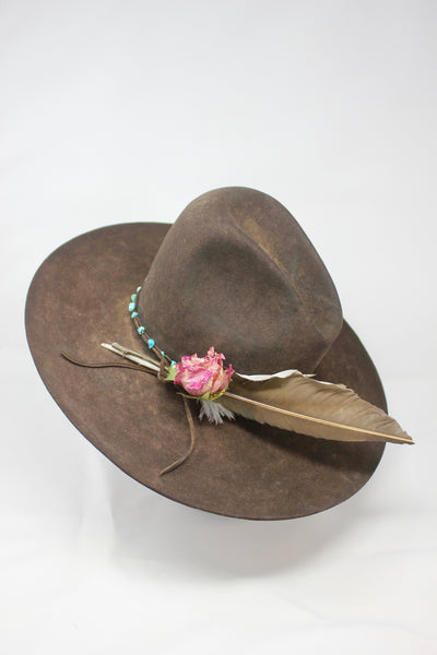 Left view of Lone Hawk wide brim tall crown western hat in vintage beaver felt featuring a hand-tied turquoise band, dried rose accent, and high-front low-back shaping.