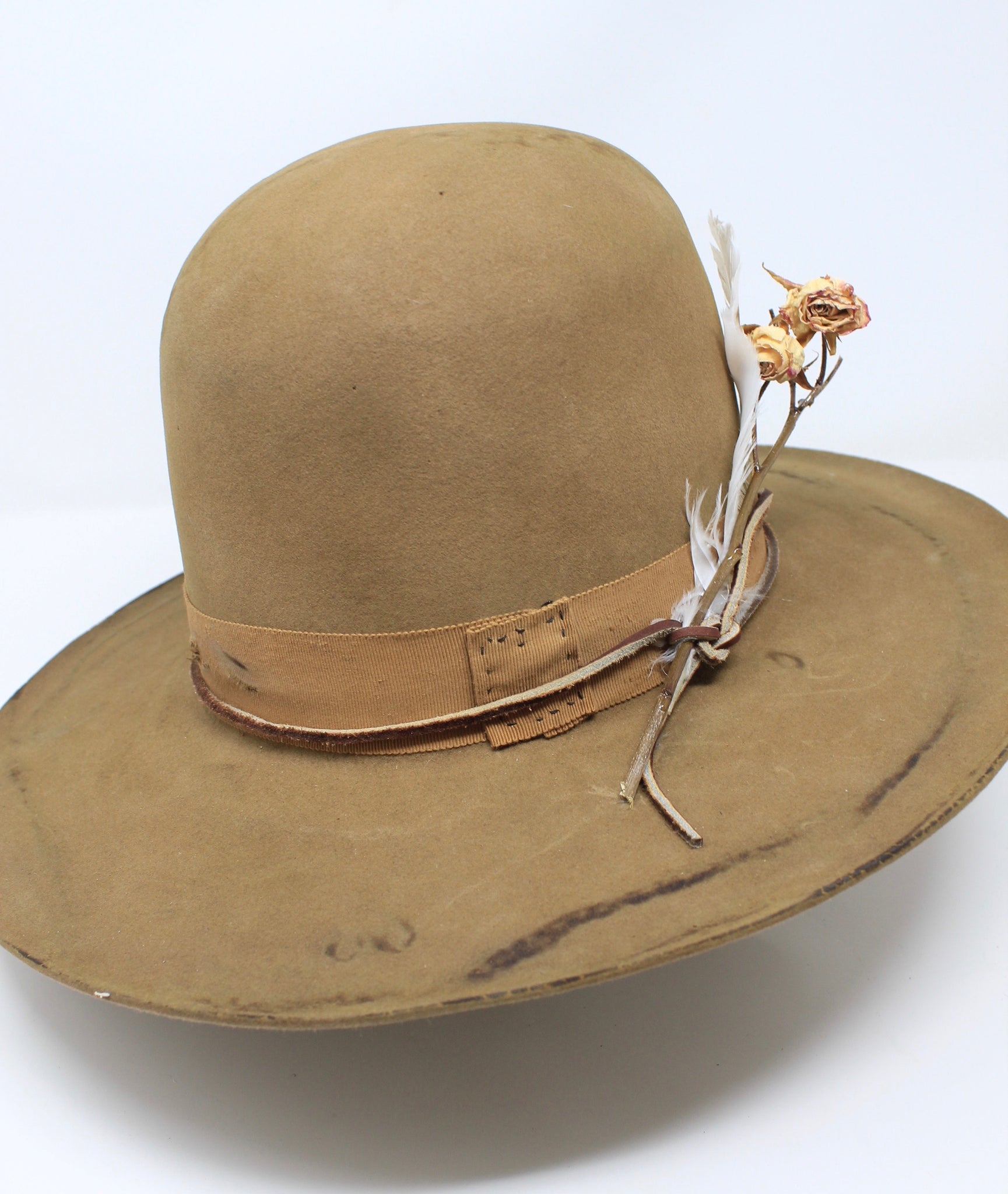 Top Left view of the Cree Mountain hat by Lone Hawk Hats featuring a tall open crown, flat brim with a slight pencil roll, hand-sewn band, feather accents, and light distressing.