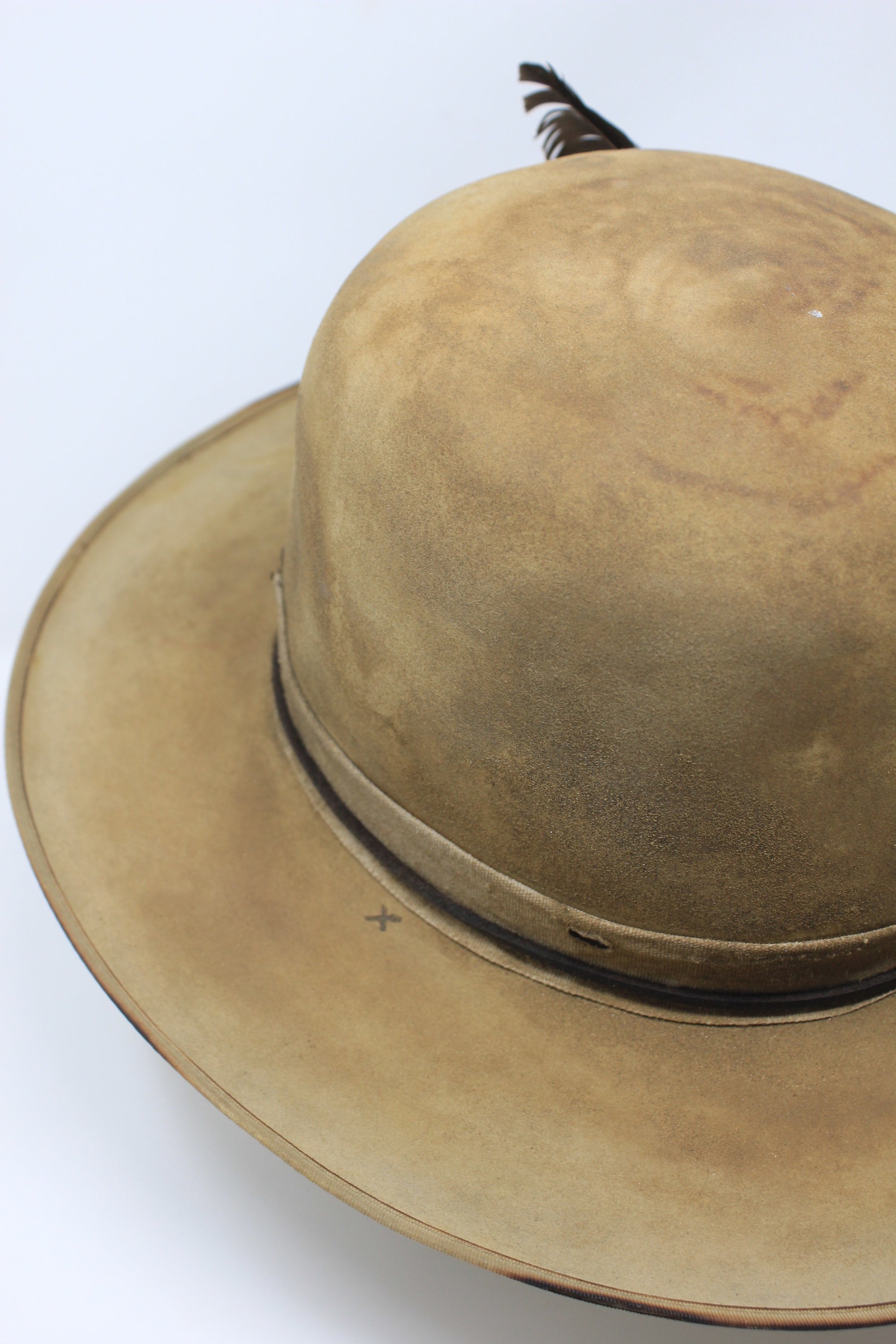 Partial top left view of the Desert Hawk hat by Lone Hawk Hats featuring a fully distressed Dust Bowl-era style, tall open crown, flat brim, and hand-sewn band.