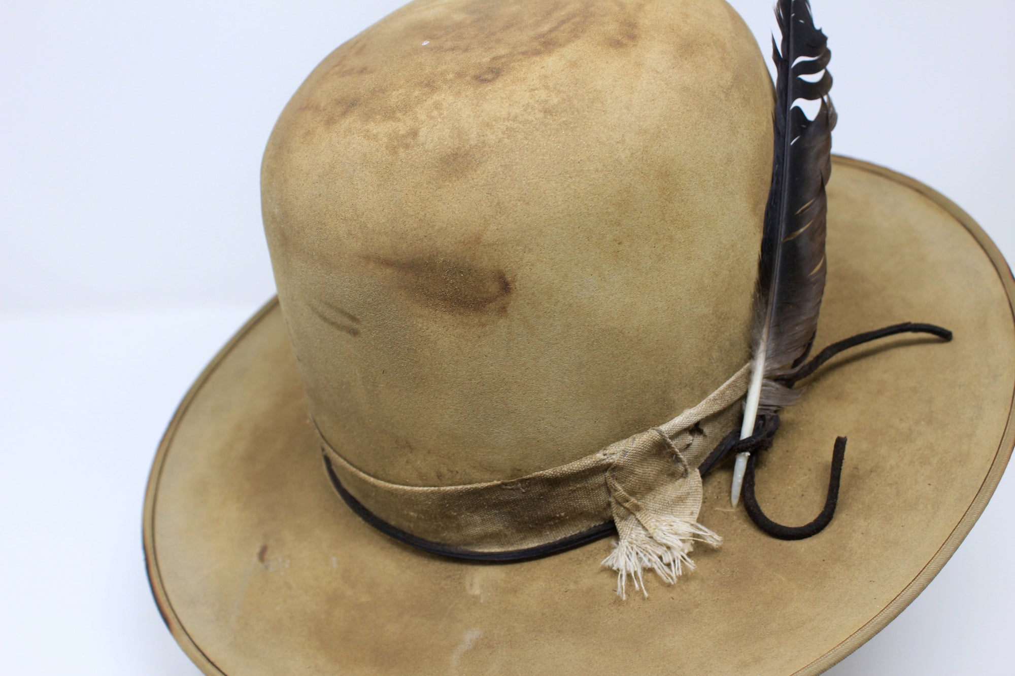 partial top left view of the Desert Hawk hat by Lone Hawk Hats featuring a fully distressed Dust Bowl-era style, tall open crown, flat brim, and hand-sewn band.