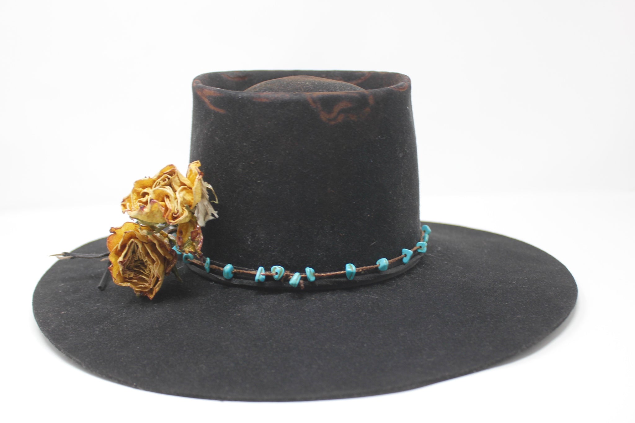 Back view of The Horse Thief Badlands custom Lone Hawk hat featuring a distressed telescope crown, wide flat brim, turquoise embellishment, and found feather detail, handcrafted in California.