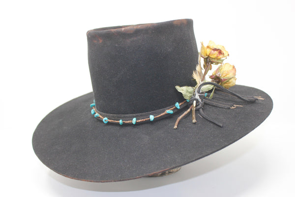 The Horse Thief Badlands custom Lone Hawk hat featuring a distressed telescope crown, wide flat brim, turquoise embellishment, and found feather detail, handcrafted in California.