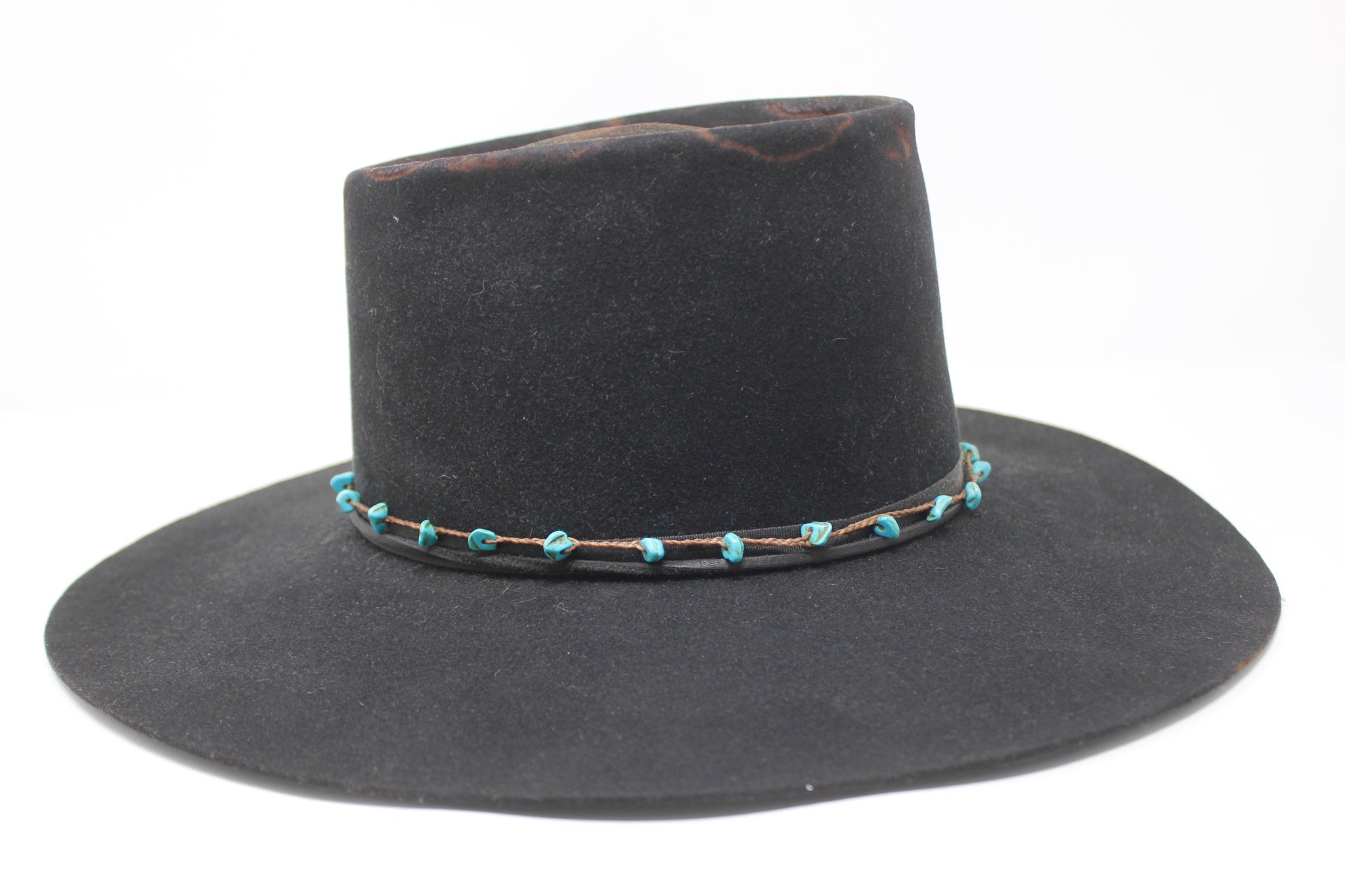 Right view of The Horse Thief Badlands custom Lone Hawk hat featuring a distressed telescope crown, wide flat brim, turquoise embellishment, and found feather detail, handcrafted in California.