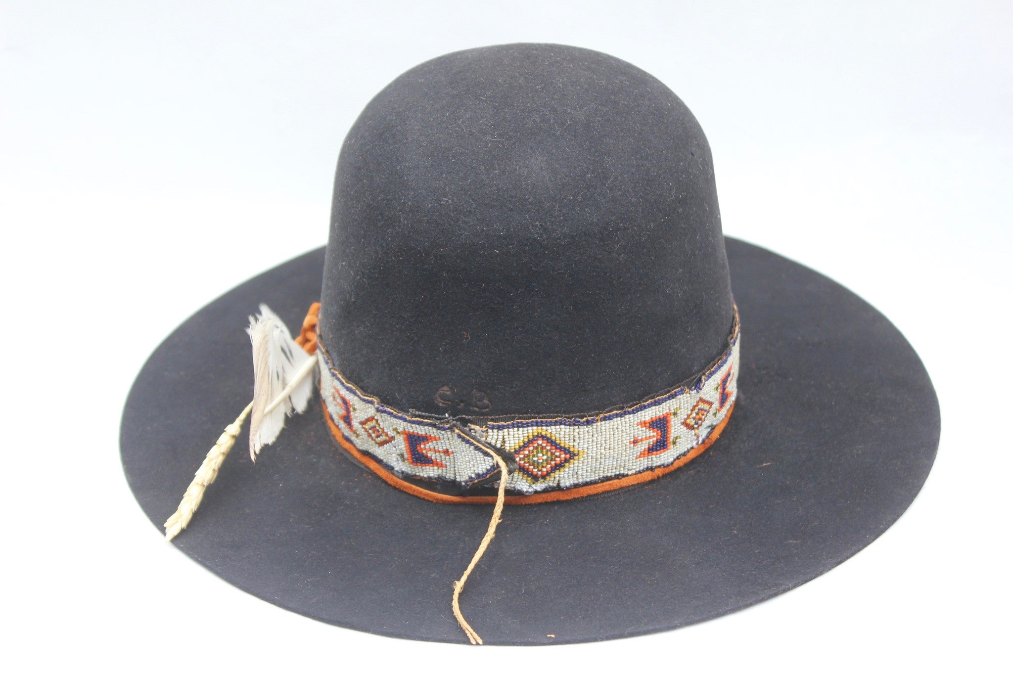 back view of The Lady Starr by Lone Hawk Hats, a one-of-a-kind open crown western hat featuring an antique Native American hand-beaded band, flat brim, and found feather.