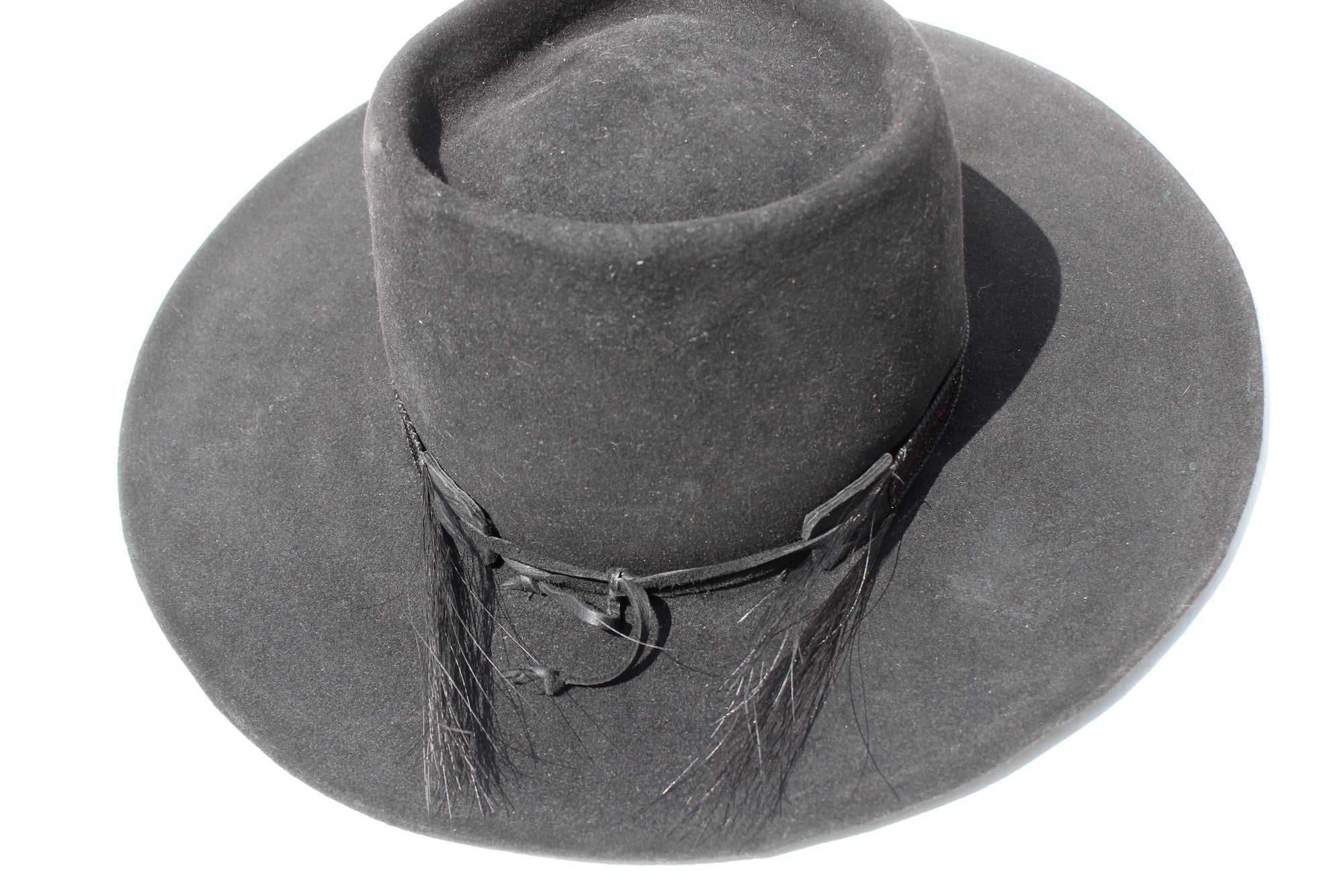 Back view of The Saturday Night Fever custom Lone Hawk hat, a handmade beaver fur blend western hat featuring a tall tear-drop crown, hand-beaded band with horsehair detail, and antique English medallion.