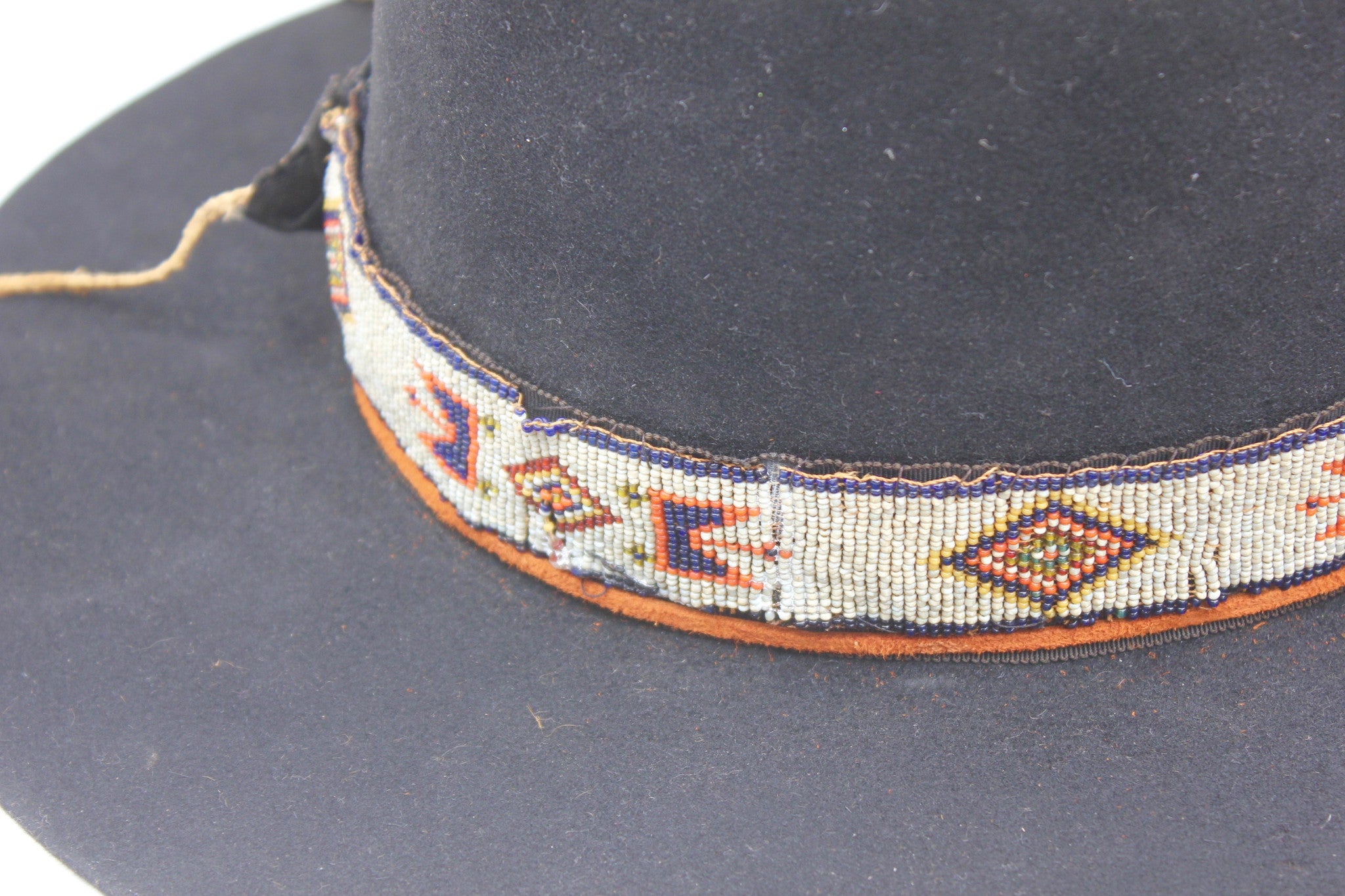 close up view of the antique Native American hand-beaded band,  on The Lady Starr by Lone Hawk Hats, a one-of-a-kind open crown western hat featuring a flat brim, and found feather.